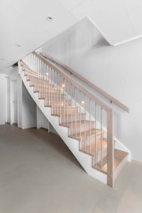 Moderne trapp med underliggende vange i lys eik med stålspiler og belysning i vegg Moderne trapp med underliggende vange i lys eik med stålspiler og belysning i vegg