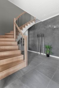 Designtrapp med underliggende vange, sortlakkerte stålspiler i rekkverk. Trinn, stusstrinn uten trappenese og stolpe i beiset langstav eik. Designtrapp med underliggende vange, sortlakkerte stålspiler i rekkverk.