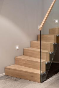 Designtrapp med sentervange, alle trappens deler i parkettmønstret eik. Tette trinn uten trappenese. Boltet glassrekkverk med håndløper i eik. Designtrapp med sentervange, alle trappens deler i parkettmønstret eik. Boltet glassrekkverk med håndløper i eik.